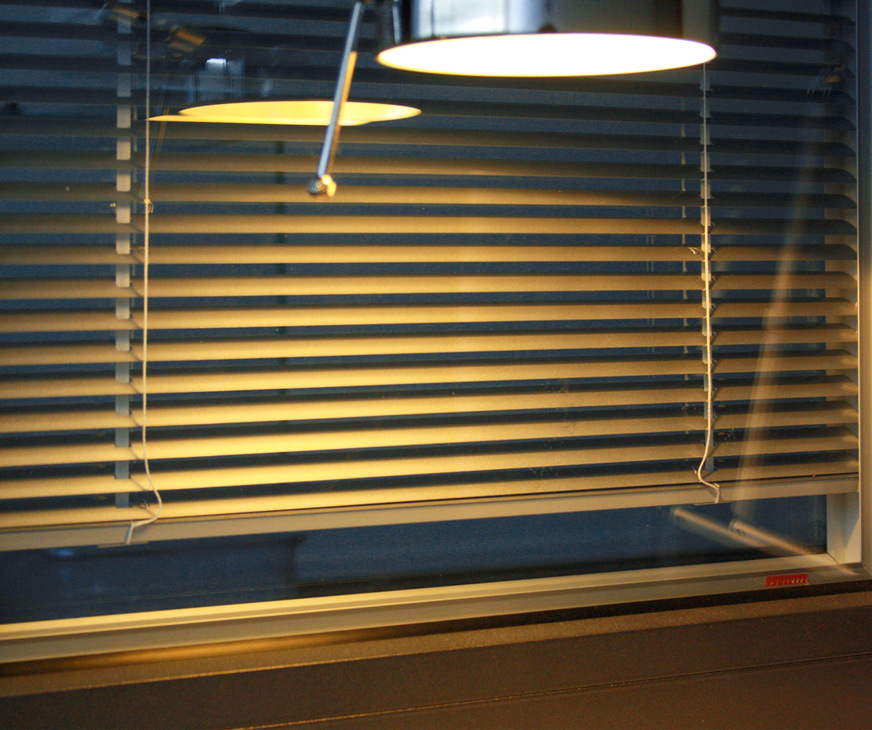 A light source on the inside in front of the pane makes the premises seem inhabited. A blind in the double-glazing cavity also provides privacy screening and indirect illumination by reflecting the light into the room.