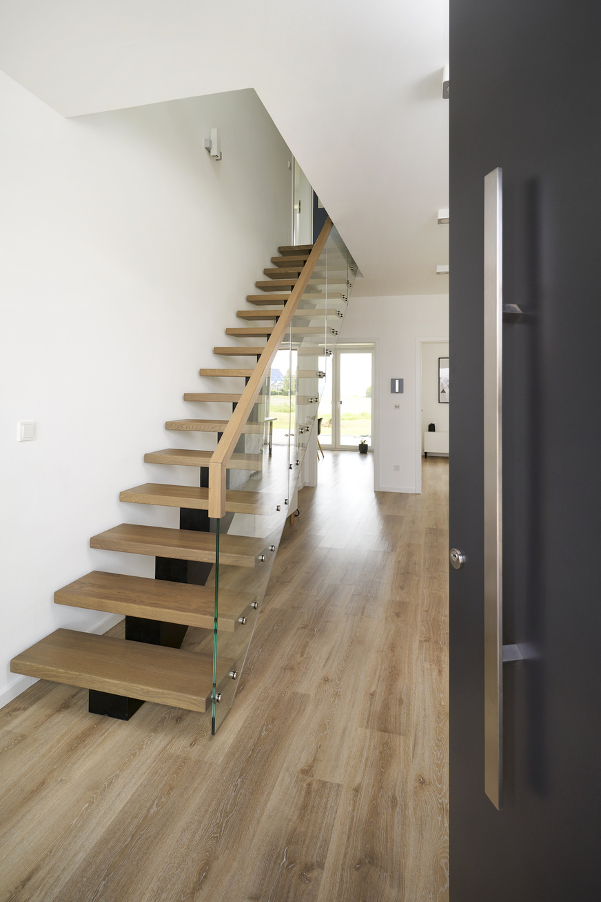 Openness and transparency are evident all over the entrance area of the new house. The single-flight staircase seems to be floating in space.