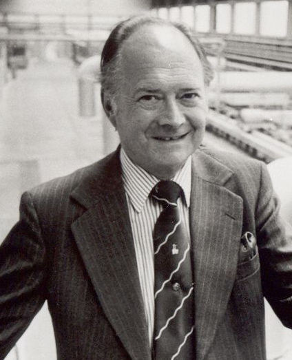 Sir Alastair Pilkington with a float glass line in the background.