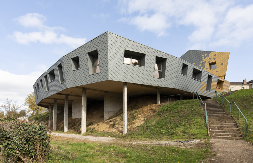 In the west, the new building - supported by pillars - rises above the steep slope that drops 6m downwards.