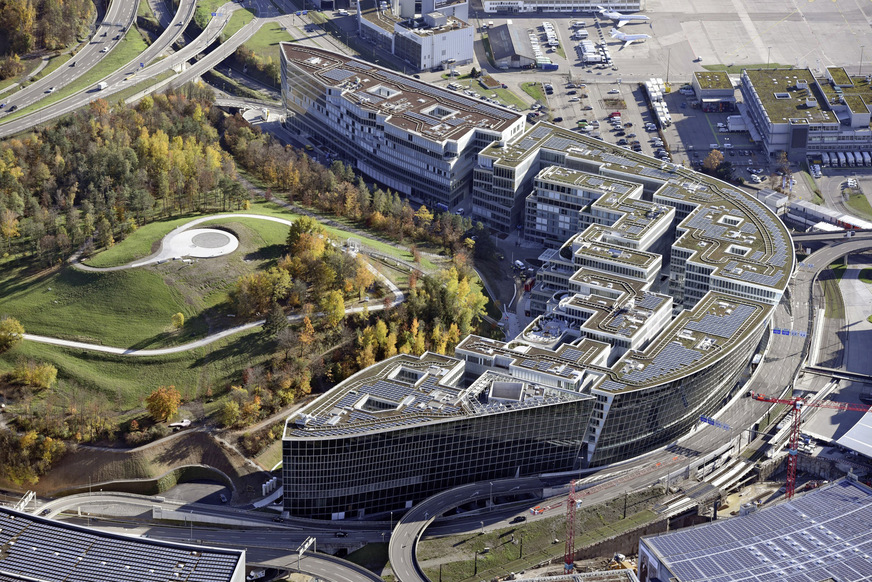 „The Circle“ aus der Feder des japanischen Architekten Riken Yamamoto schmiegt sich an einen Hügel, der von der Flughafenstraße umfahren wird – daher der Name „The Circle“.