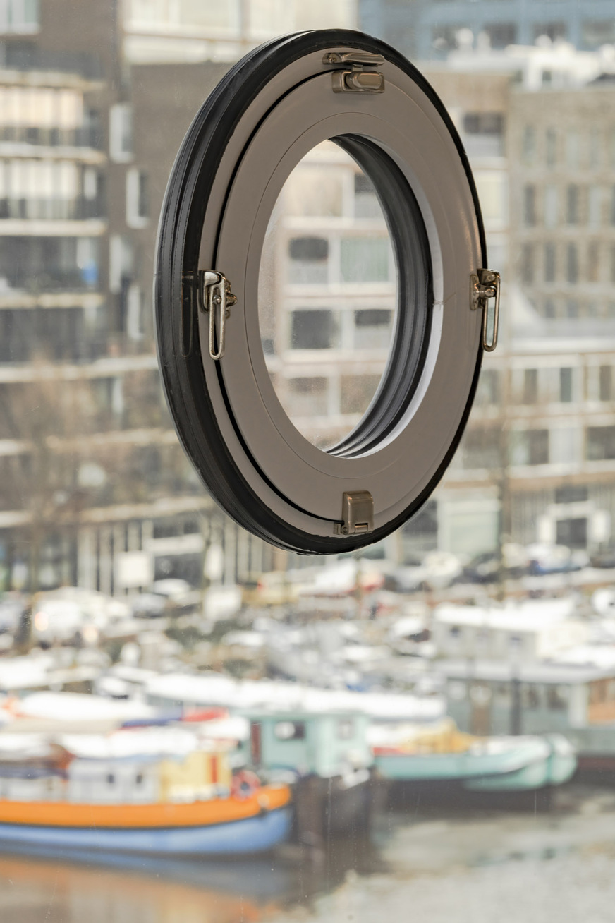 The portholes are secured with an edge seal made of silicone and inserted floatingly into the circular surface cut-outs of the fixed glazing.