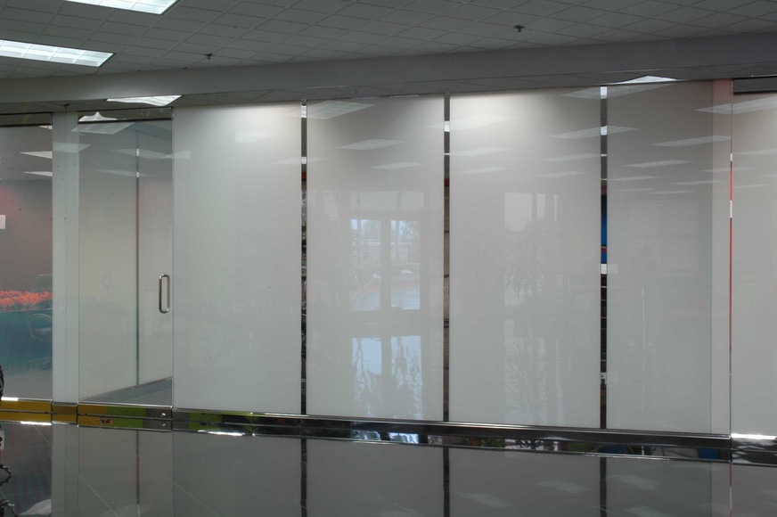 Glas Mayer produces its switchable glass GMVG Smart Glass as laminated glass alternatively with a white or grey LC film. Here an office or meeting room, on the left with the glass opaque, on the right transparent.