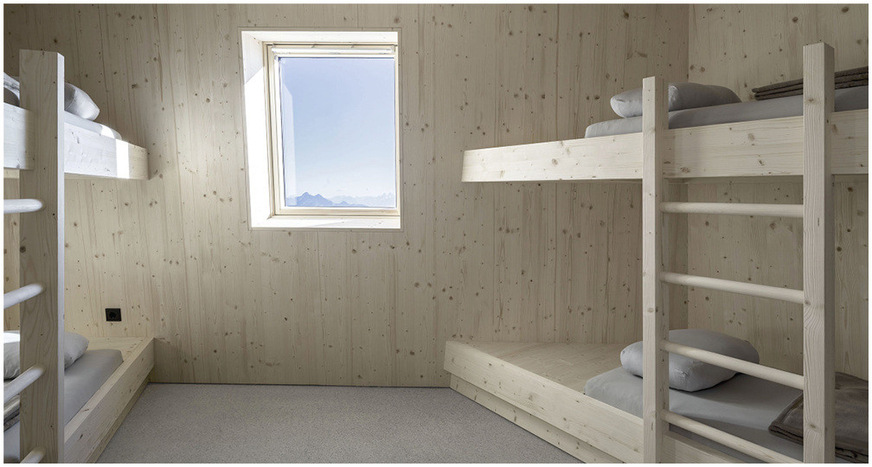 Like the rest of the interior, the guest rooms are panelled and furnished with untreated spruce wood. The view through the Velux windows makes the mountain landscape appear like a painting.
