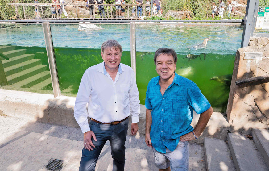 The director of Krefeld Zoo, Dr. Wolfgang Dreßen (r.), with the sales manager of Vetrotech Saint-Gobain Germany, in front of the panorama glass pane of the penguin pool.
