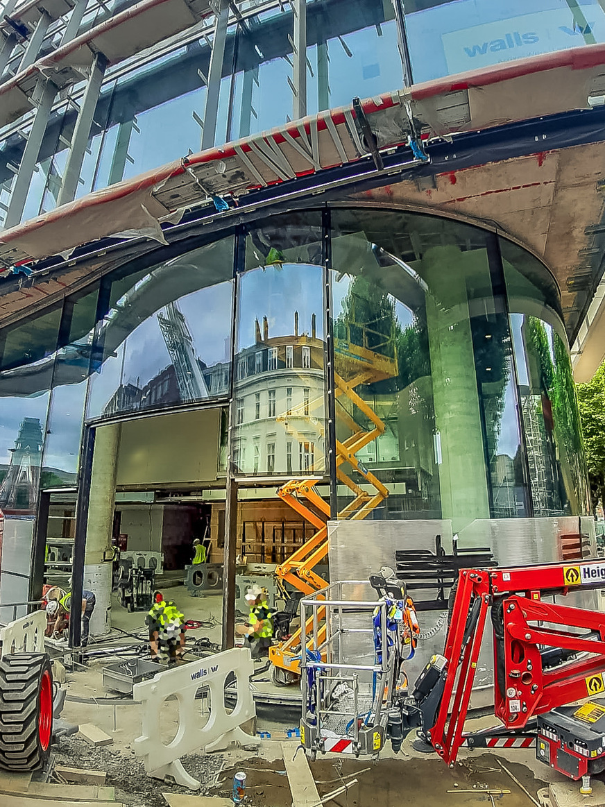 Installation of the corrugated panes, weighing over 2t, under projections and behind columns.