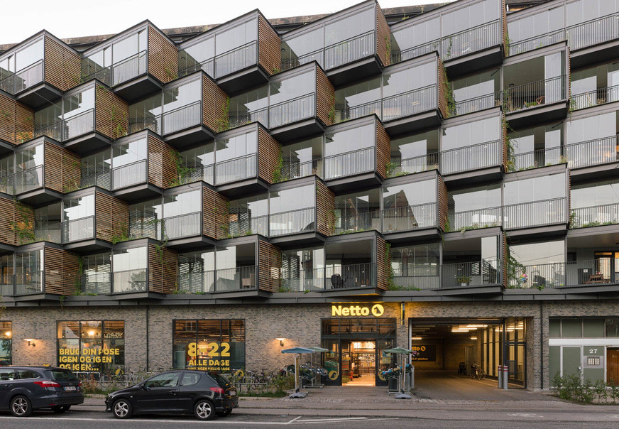 In Frederiksberg, Denmark, the facade of a residential building from the 1960s was renovated and extended with fanned-out cubes. The space gained can be used by the residents as additional living space.