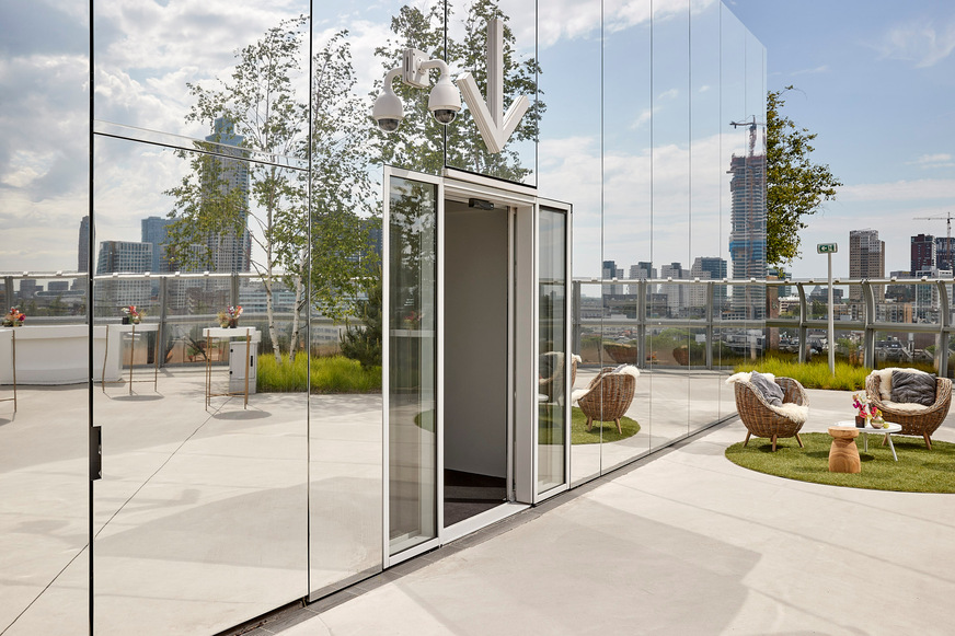 The sliding door system blends harmoniously into the mirror surface of the exterior facade.