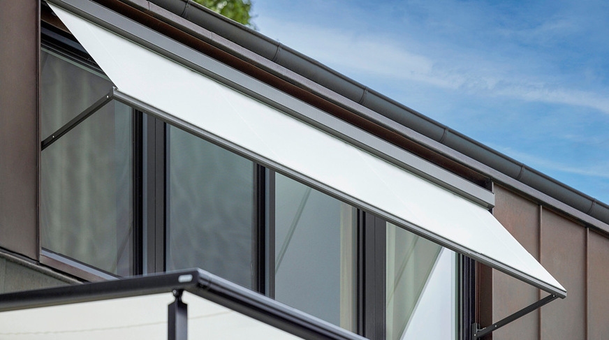 Only the awning fabric was replaced on the existing drop-arm awning, which shades a large dormer window.