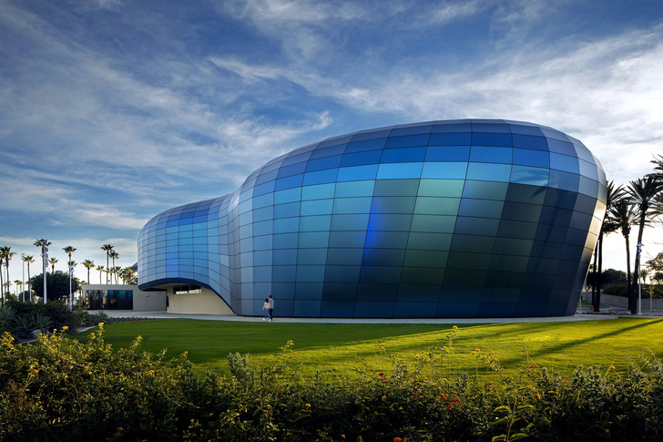 The façade, which also doubles as a ventilated rain screen, is constructed of 839 non-reflective glass panels, each of which is uniquely sized and shaped to accommodate the sweeping curves of the building’s form.