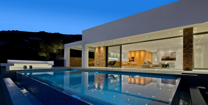 A 9-by-2.90-metre floor-to-ceiling sliding system provides direct access from the interior living and dining area to the terrace and swimming pool.