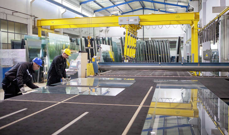 Quality is one key competence of the company: Here you can see two workers checking the glass edge after cutting. - © Lisec
