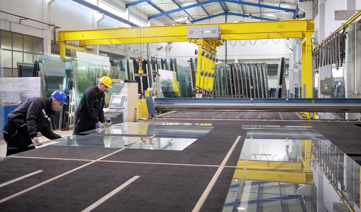 Quality is one key competence of the company: Here you can see two workers checking the glass edge after cutting.