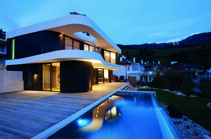 The snow-white ceilings form an exciting contrast to the anthracite-coloured wooden cladding of the building.