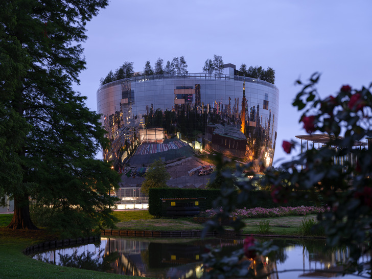 The mirrored facade reflects the environs of the building and makes the  surrounding buildings look larger than they are. 