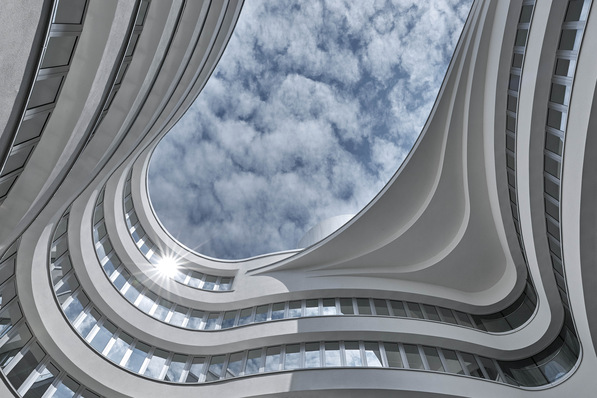 In the new building, horizontal bands of glass and snow-white glazed large-format ceramic tiles wrap themselves around the building as if on a seemingly endless band.
