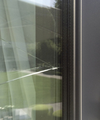 View of the crack at the vertical edge of the middle float glass pane of the insulating glass unit.