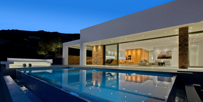 A 9-by-2.90-metre floor-to-ceiling sliding system provides direct access from the interior living and dining area to the terrace and swimming pool.