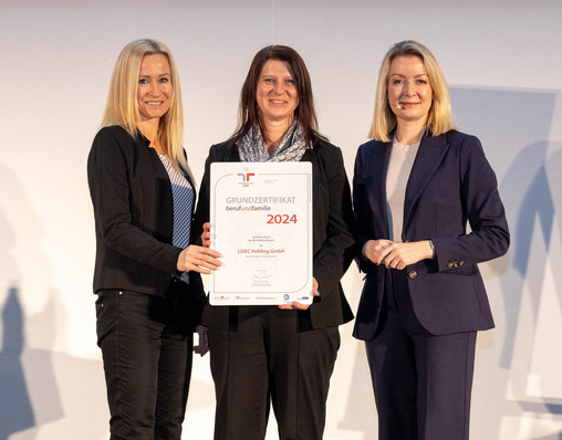 Three women holding a certificate and smiling at an award presentation event. - © Lisec