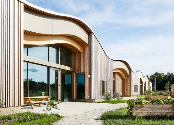 The curved, green roof blends perfectly into the floodplain landscape.